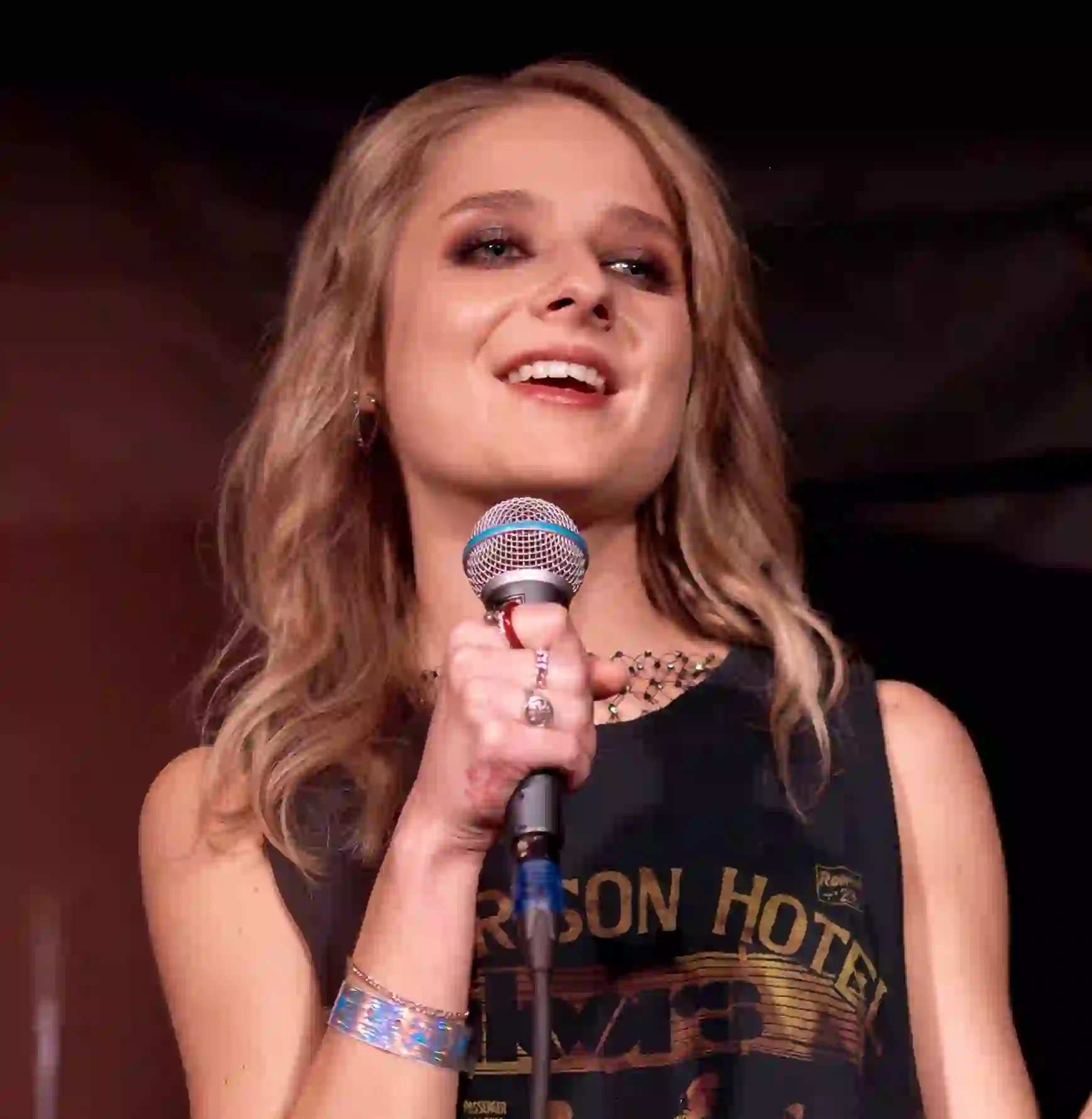 Singer Jackie Evancho performing live on stage with a microphone.
