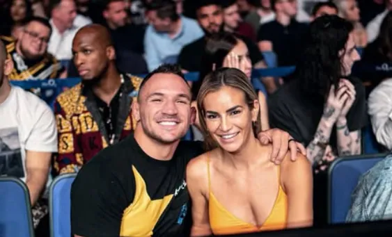 Dr. Brie Willett smiling next to her husband Michael Chandler at an event.