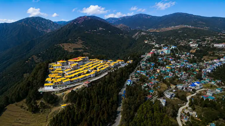 Aerial view of yellow roofed Tawang Monastery perched on a mountain slope in Arunachal Pradesh.