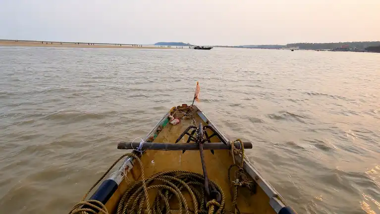 View from the front of a wooden boat crossing the Subarnarekha estuary toward Talasari Beach.