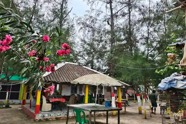 Mud cottage and outdoor dining setup at a Mousuni Island beach camp