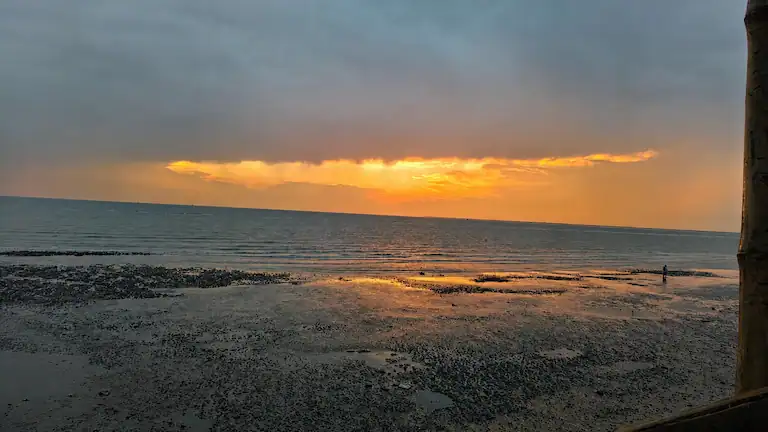 Dramatic sunset over the muddy seabed during low tide at Mousuni Island.