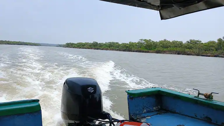Motorboat traveling through the Subarnarekha River towards Subarna Island.